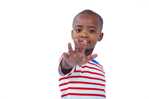 Boy holding his hand on the camera on white screen