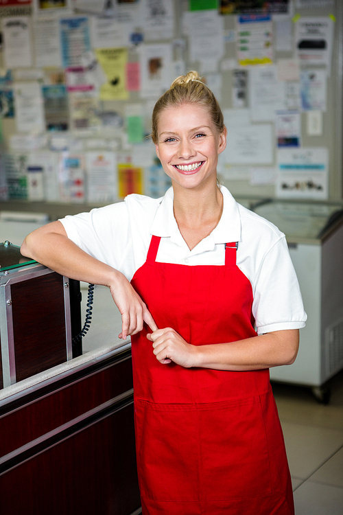 Portrait of smiling shop assistant with red apron