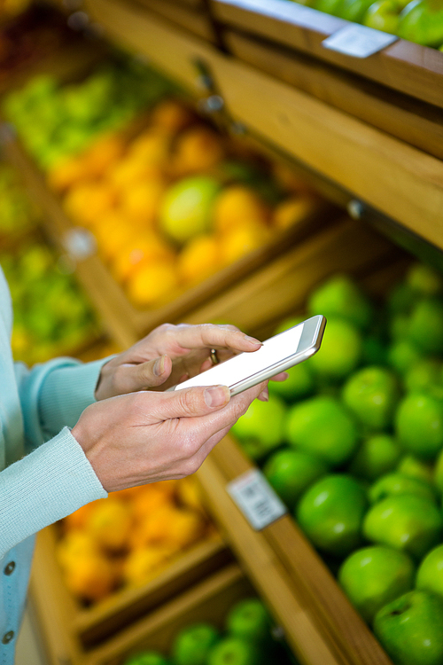 Close up view of a woman using her smartphone in supermarket