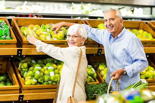 Smiling senior couple at the grocery shop looking at the camera