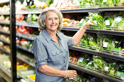 Senior woman picking out some vegetables in supermarket