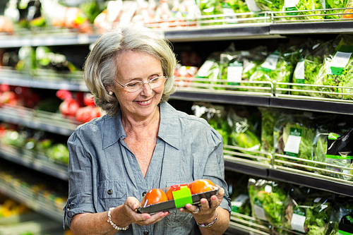 Senior woman picking out some vegetables in supermarket