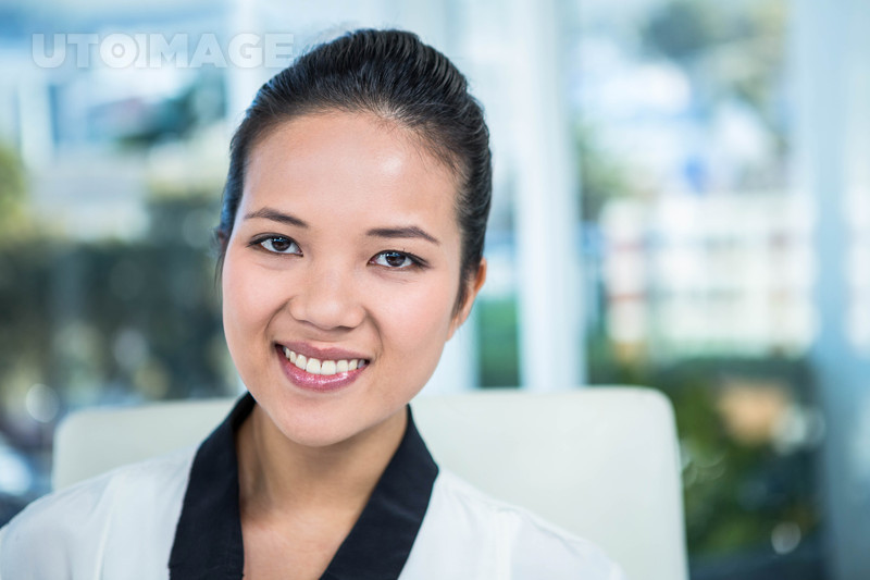 유토이미지 | Smiling businesswoman with notes at desk