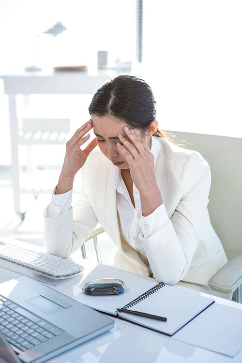 Stressed businesswoman working at her desk in work