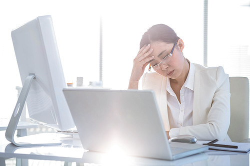 Stressed businesswoman working at her desk in work