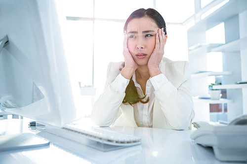 Stressed businesswoman working at her desk in work