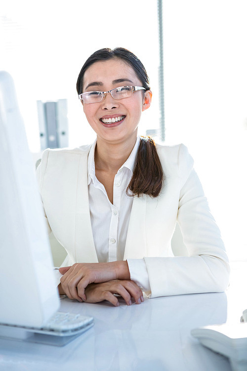 Smiling businesswoman working at her desk in her office