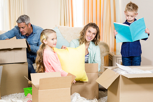 Cute family opening boxes in living room