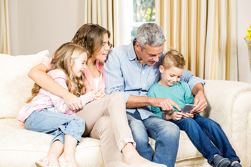 happy family using phone on sofa in the living room