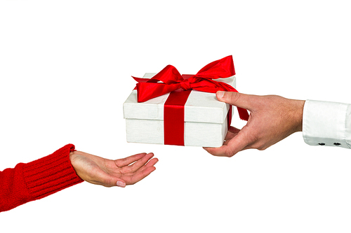 Cropped hand of man giving gift to woman on white background