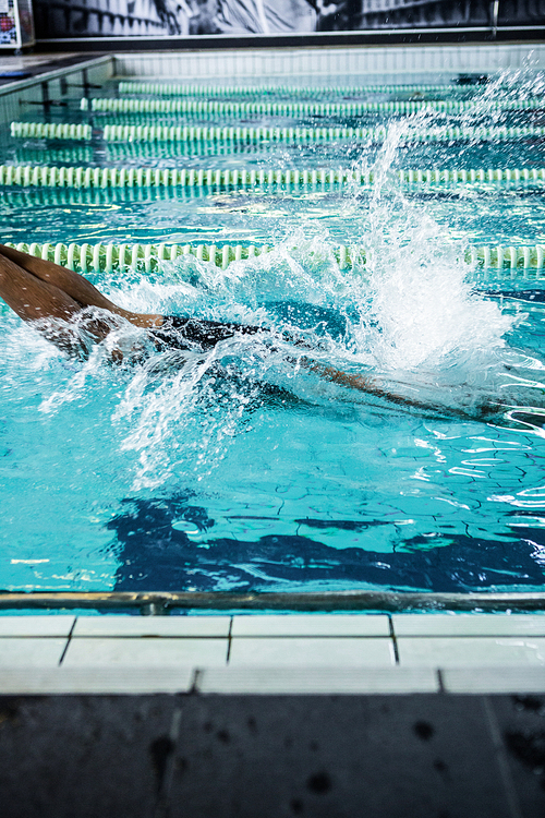 side view of fit swimmer about to dive into the swimming pool