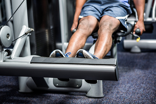 Cropped image of man using exercise machine at gym
