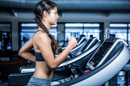 Fit woman jogging on treadmill at gym