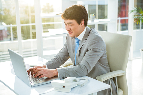 Asian businessman using his computer in his office