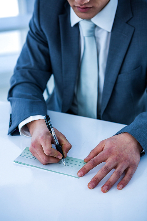 Close up view of businessman completing a cheque