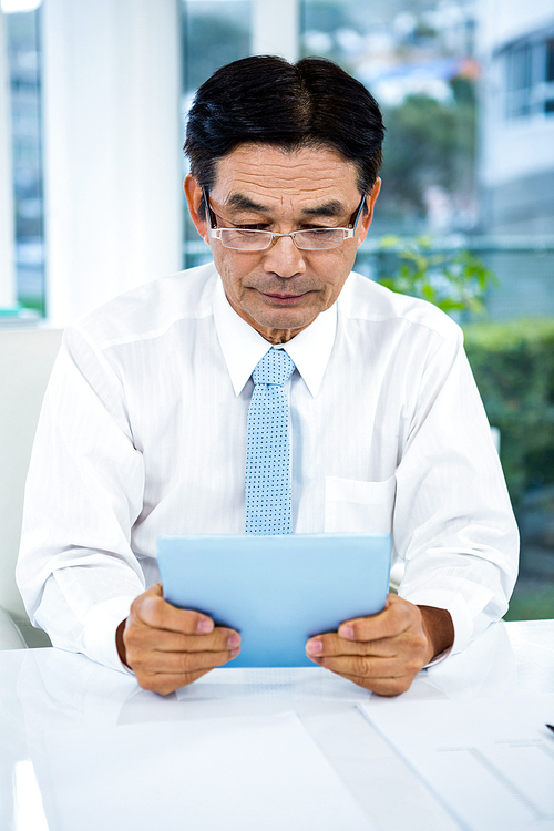 Businessman using his tablet in office
