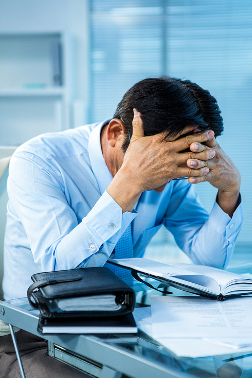 Worried businessman working at his desk in office