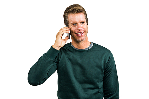 Smiling man talking on mobile phone while standing on white background