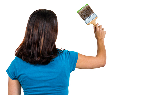 Rear view of woman holding paint brush against white background