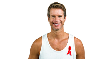 Portrait of man wearing aids ribbon on vest against white background