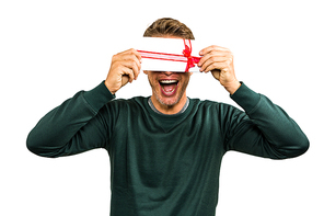 Cheerful man hiding face with gift against white background