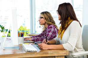 Two girls work at office on computer and tablet