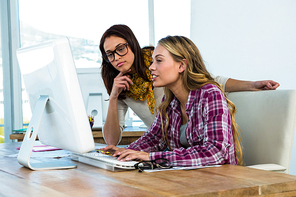 Two girls work at office on computer and tablet