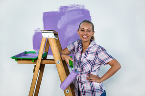 Smiling woman painting a wall in new house