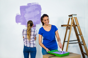 Friends painting a wall in new house