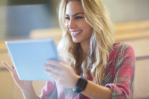 Smiling female student using tablet in lecture hall