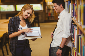 Couple with books looking at each other in the library