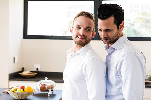 Smiling gay couple in the kitchen at home