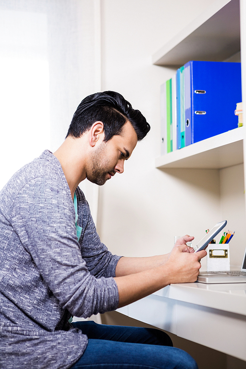 Focused man using tablet at home