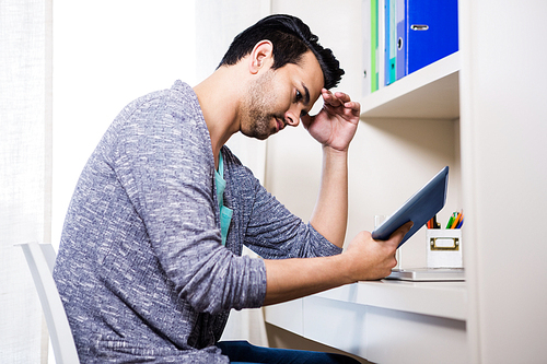 Focused man using tablet at home