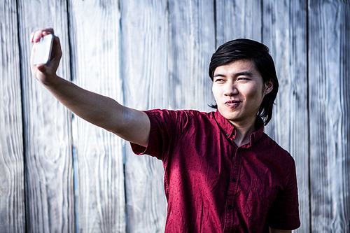 Hipster man taking a selfie on wooden background