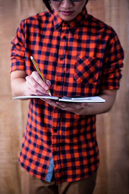 Hipster taking notes on notebooks on wooden background