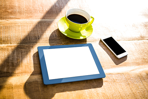Cup of coffee and tablet pc on a desk
