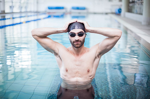 Focused man wearing swim cap and goggles at the pool