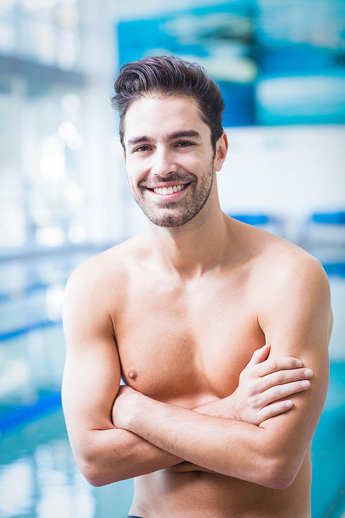 Smiling man with arms crossed at the pool