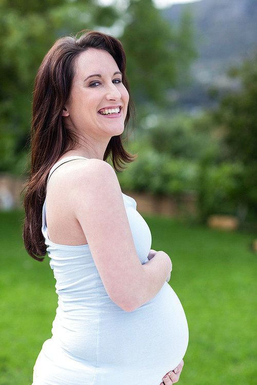 Portrait of smiling pregnant woman outside