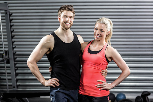 Happy fit couple embracing at crossfit gym