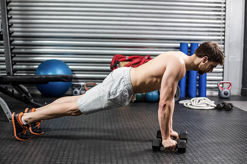 Man doing push up with dumbells at crossfit gym