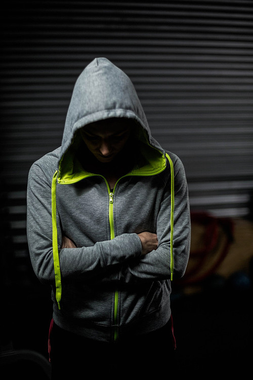 Athlete wearing hood with head down at crossfit gym