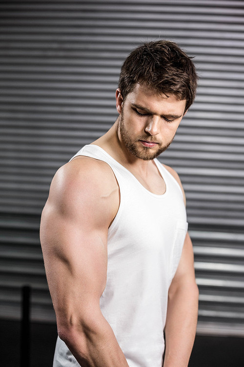 Serious fit man posing at crossfit gym