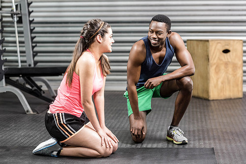 Fit couple taking a break at crossfit gym