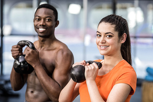 Athletic man and woman working out at crossfit gym