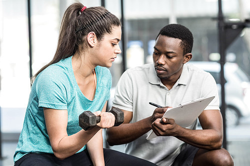 Trainer giving advice to woman at crossfit gym