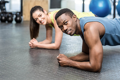 Athletic man and woman working out at crossfit gym