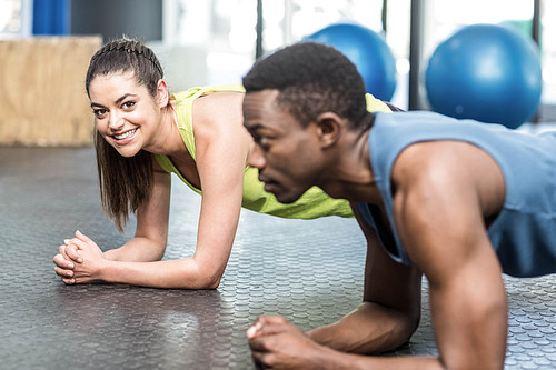 Athletic man and woman working out at crossfit gym