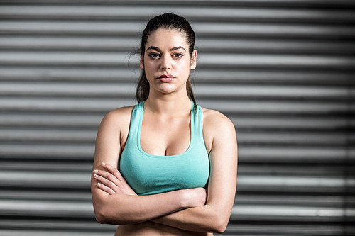 Portrait of fit woman with crossed arms at crossfit gym